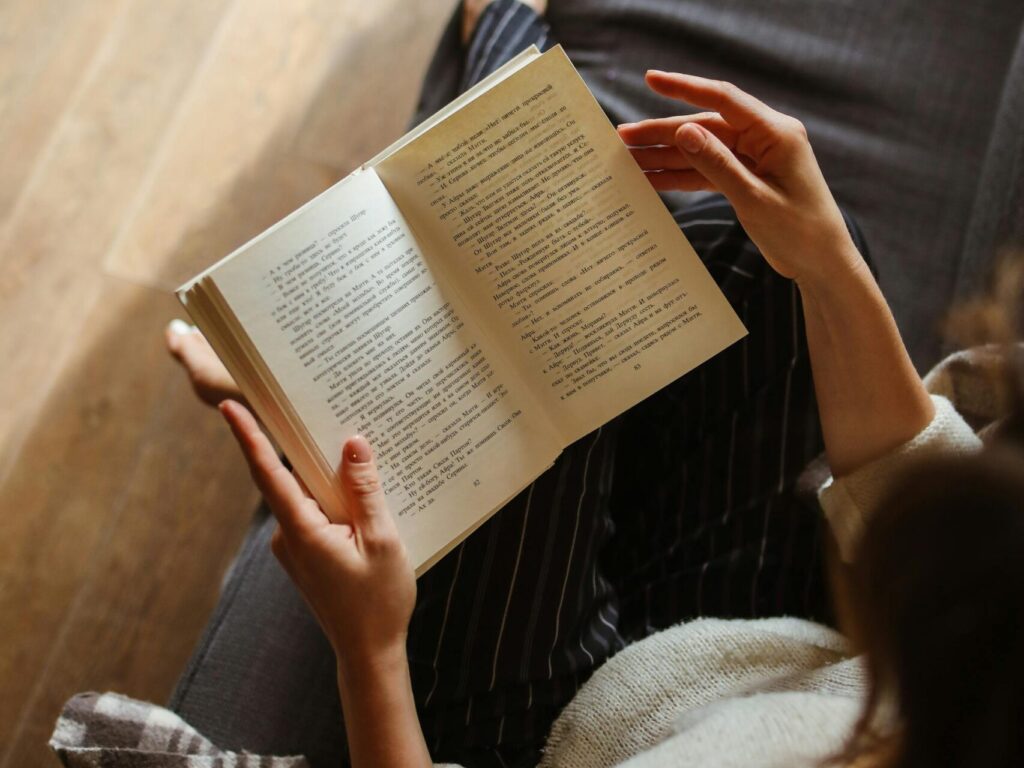 Women sitting on a sofa and reading a self-improvement book